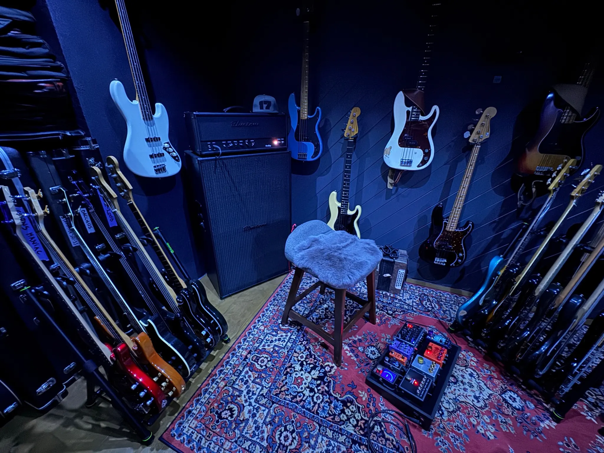 The Gruuvik Chamber, with basses, chair and pedalboards under the room’s blue lighting