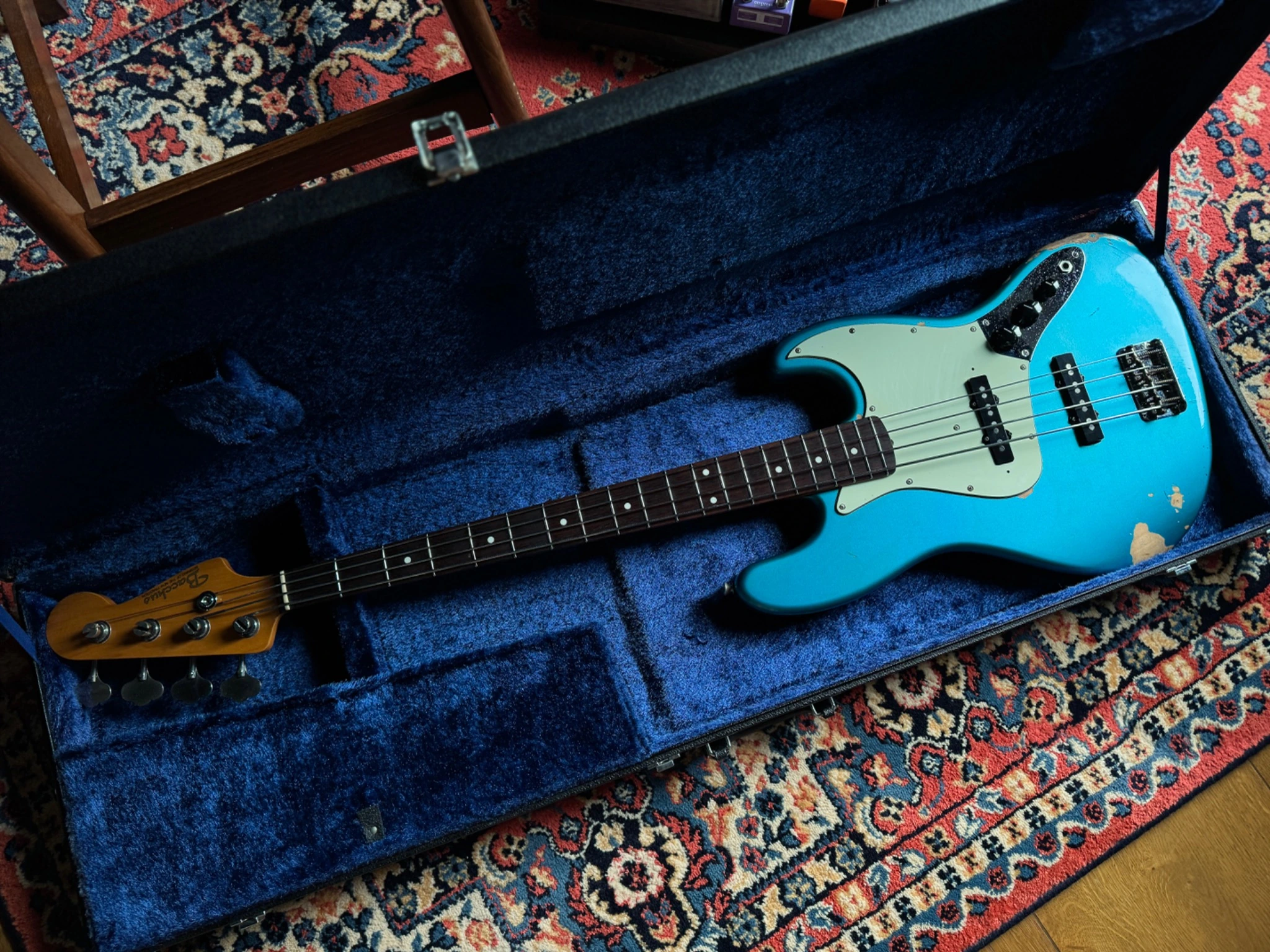 A turquoise bass resting in its blue-lined case in the Gruuvik Chamber