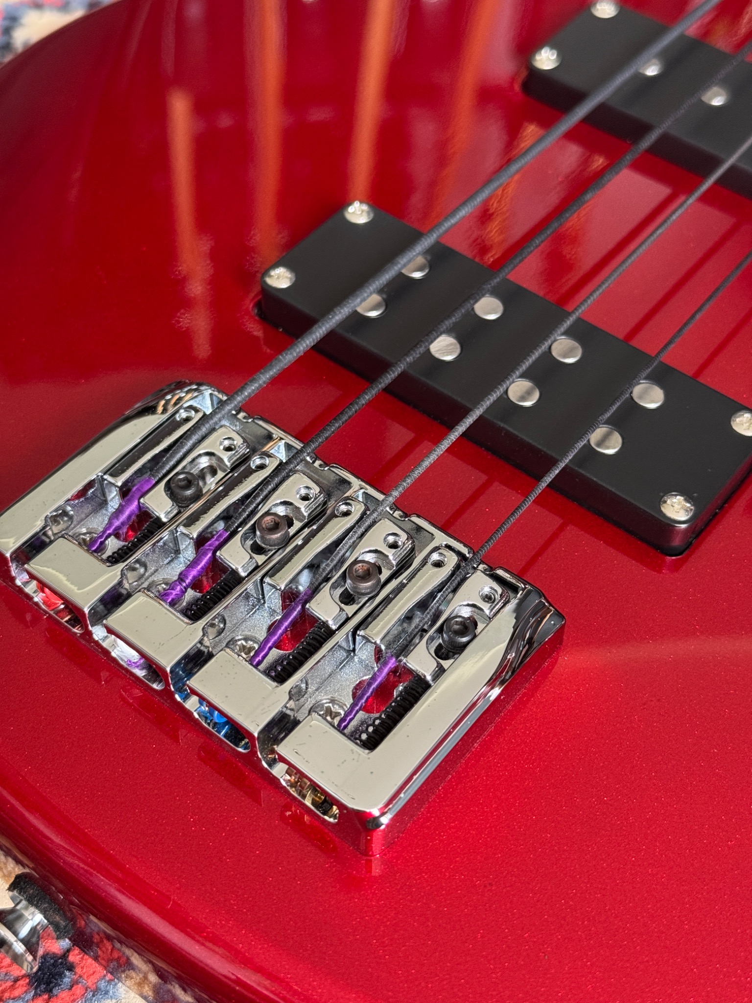 Close-up of the bridge, strings and pickup on the red body