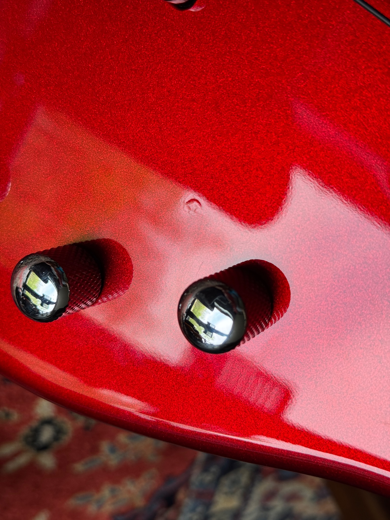 Close-up of the red body and control knobs, with a small finish mark visible above them.